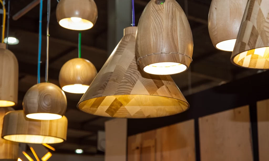 Assorted wooden pendant lights crafted in unique shapes, showcasing bespoke lighting in a luxury interior setting.
