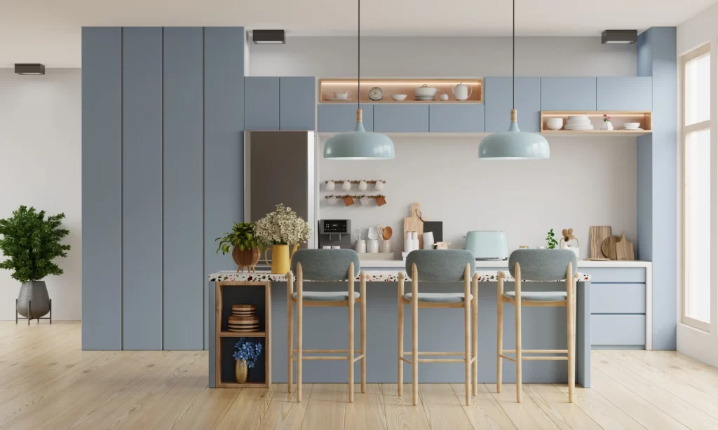 Modern kitchen with soft blue cabinetry and pendant lights, illustrating thoughtful interior lighting design.