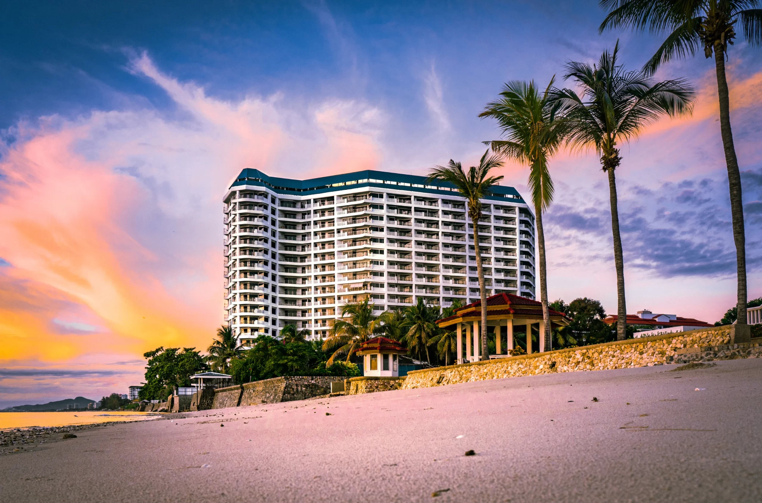 Luxury hotel exterior view during sunset, showcasing a premium beachfront location, aligning with the concept of a successful hotel opening.
