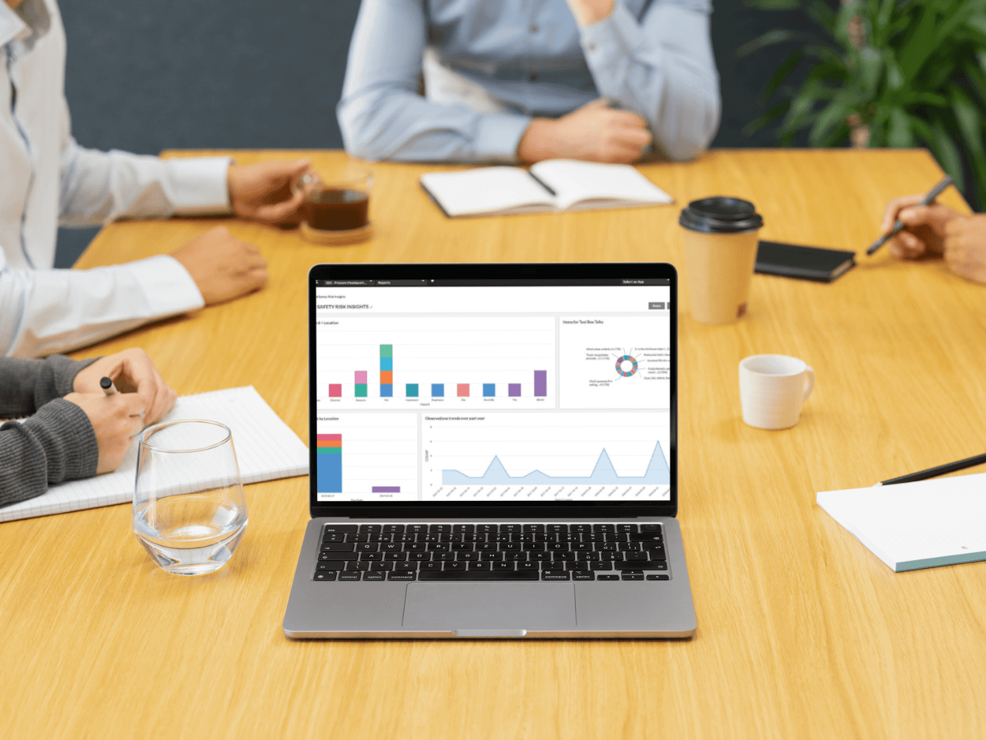 Business team using construction management software on a laptop during a meeting.