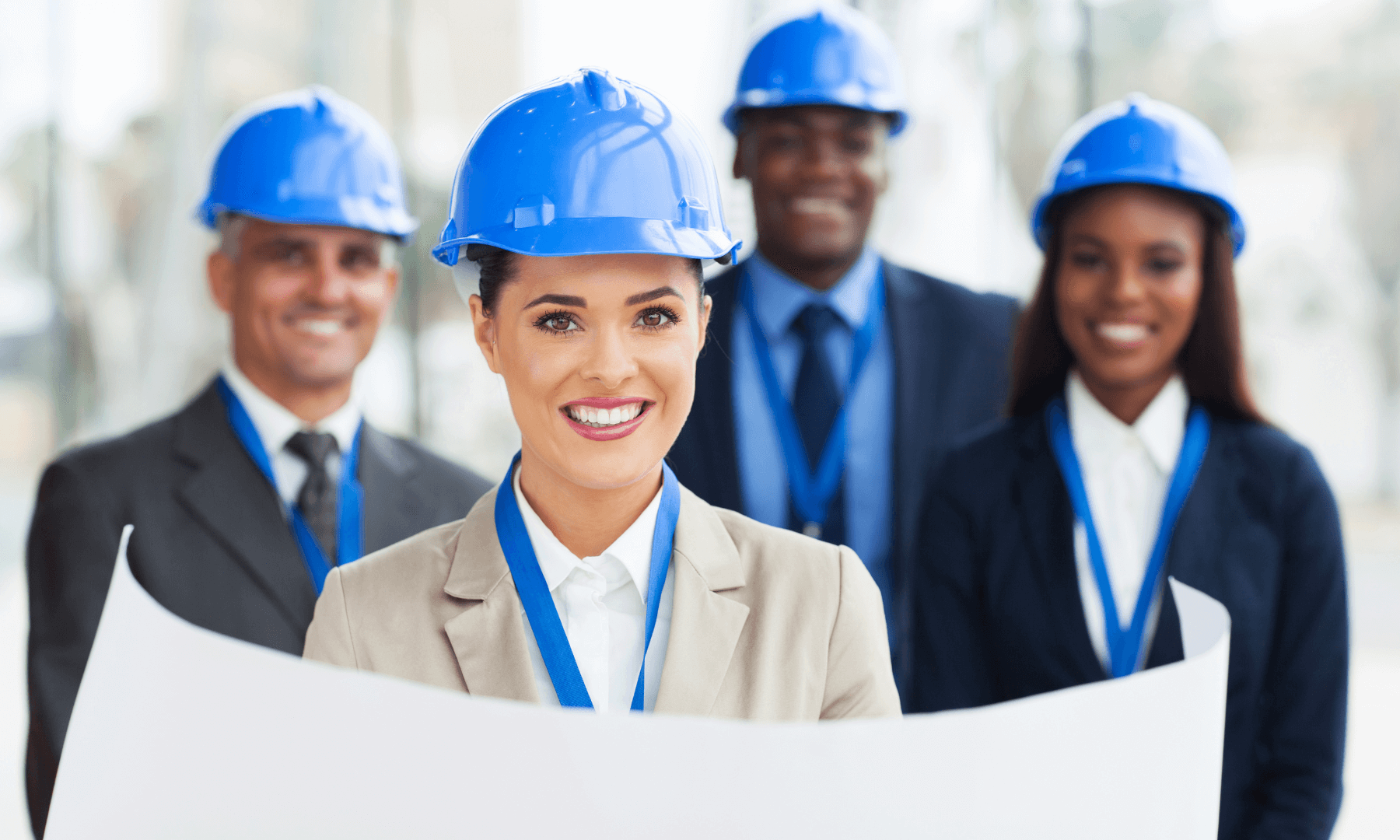 Diverse team of professionals in blue construction helmets showcasing leadership in project management consulting for hospitality development.